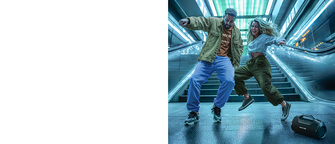 Dos jóvenes bailan en una estación de metro vacía, delante de una escalera mecánica metálica, al son de la música que sale de un altavoz de Hama.